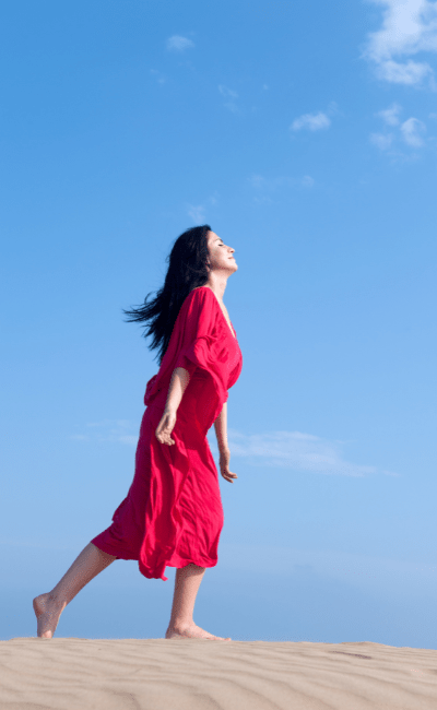 Woman walking out of desert happily in freedom